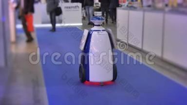 机器人技术展览会上广告机器人沿着蓝色地毯移动的肖像。